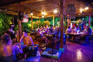 un groupe de personnes assises dans un bar dans l'établissement The Grateful Hotel, à Playa Grande