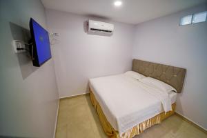 una piccola camera con letto e TV di Hotel Uptown Semenyih a Semenyih