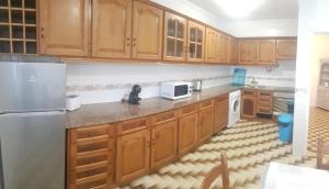 cocina con armarios de madera y nevera blanca en VieiraMar en Praia da Vieira