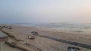 una playa con vehículos estacionados en ella junto al océano en VieiraMar en Praia da Vieira