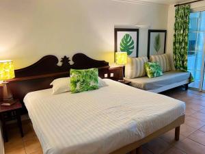 une chambre avec un grand lit et un canapé dans l'établissement Studio vue mer RDC dans village vacances, à Sainte-Luce