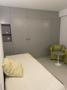 une chambre d'hôpital avec un lit et une chaise dans l'établissement Appartement studio neuf avec parking à 50m de la plage, à Cannes