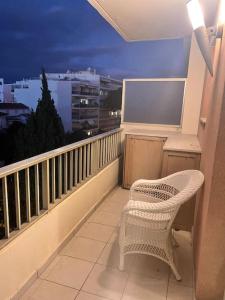 une chaise blanche assise sur un balcon la nuit dans l'établissement Appartement studio neuf avec parking à 50m de la plage, à Cannes