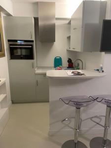 - une cuisine avec un comptoir et deux tabourets dans l'établissement Appartement studio neuf avec parking à 50m de la plage, à Cannes