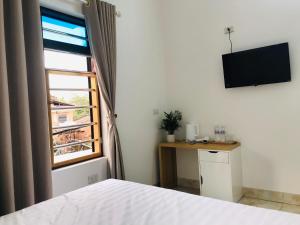 a bedroom with a bed and a television on the wall at Tam Coc Sunset Homestay in Ninh Binh