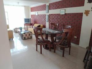 a dining room with a table and chairs and a brick wall at Casa con piscina para descanso in Chachagüí