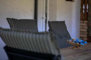 two chairs sitting on a wooden table with blue packets at Holiday Residence Burić in Visoko