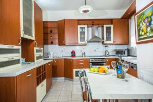 uma cozinha com armários de madeira e uma mesa com uma tigela de fruta em Vasiliki Island view house em Agios Nikolaos