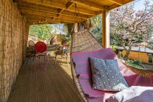 a covered porch with a couch and a chair at Glastonbury, large House Stunning views 2 to 5 bedrooms, 3 receptions turn into bedrooms in Glastonbury