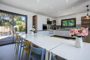 a kitchen with a large white table and chairs at Villa Ryx in Grimaud