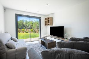 salon z 2 kanapami i telewizorem z płaskim ekranem w obiekcie Villa Ryx avec piscine w mieście Grimaud