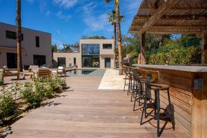 a wooden boardwalk with chairs and a bar at Villa Ryx in Grimaud