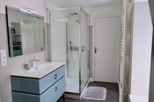 bagno bianco con lavandino e doccia di Contes à Rebours - Chambres d'hôtes a Morlaix