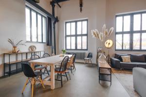 ein Wohnzimmer mit einem Tisch und Stühlen in der Unterkunft ElbQuartier Apartments Magdeburg 'Fabrik61' in Magdeburg