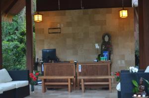 a patio with two benches and a table and a tv at Lanna Ban Hotel in Puerto Viejo