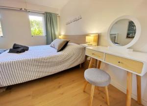 Schlafzimmer mit einem Bett, einem Schreibtisch und einem Spiegel in der Unterkunft Green Patio in Antibes