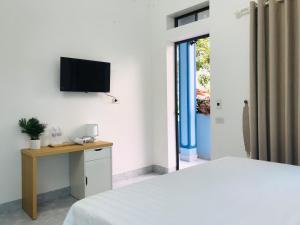 a bedroom with a bed and a tv on the wall at Tam Coc Sunset Homestay in Ninh Binh