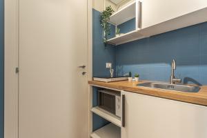 a kitchen with a sink and a microwave at Vittoria Garden Suites in Rome