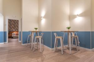 una stanza con tre sgabelli da bar e una parete blu di Vittoria Garden Suites a Roma