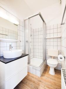 a white bathroom with a sink and a toilet at Haus Menno Janssen - Doppelzimmer in Norderney