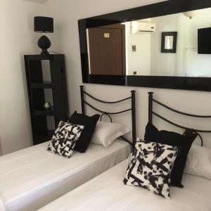 una camera con 2 letti con cuscini bianchi e neri di Paradiso Country House a Pescara