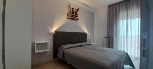 ソットマリーナにあるAppartamenti San Marcoのベッドルーム1室(ベッド1台、大きな窓付)