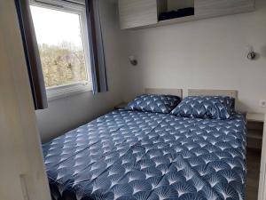 uma cama num pequeno quarto com uma janela em Vakantiechalet Jonagold 4 personen em Hengstdijk