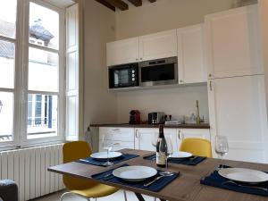 een keuken met een houten tafel met stoelen en een eetkamer bij Studio rénové et tres fonctionnel, Marly-le-Roi in Marly-le-Roi