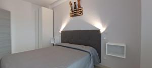 ソットマリーナにあるAppartamenti San Marcoのベッドルーム1室(壁に照明付きのベッド1台付)
