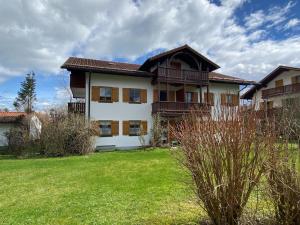 ein großes Haus mit grünem Rasen davor in der Unterkunft Bayern Lodge Bergen in Bergen