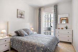 biała sypialnia z łóżkiem i oknem w obiekcie Apartamento Atlántico w mieście Barbate