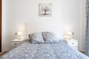 sypialnia z łóżkiem z dwoma szafkami nocnymi i dwiema lampami w obiekcie Apartamento Atlántico w mieście Barbate