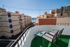 a balcony with a table and chairs on a roof at COVESA I Centro Levante Beach in Benidorm