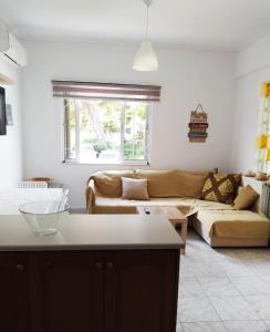 Aegean Breeze Beach House في أرتيميدا: غرفة معيشة مع أريكة وطاولة