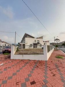 uma casa branca com um passeio de tijolos em frente em Simple Home Taiping 简居 @ Suria Aman em Kamunting