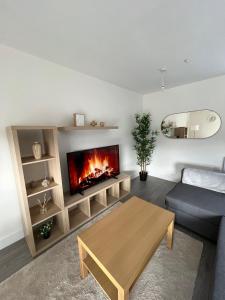 a living room with a couch and a fireplace at 2 Bedroom City Centre Apartment in Hemel Hempstead in Hemel Hempstead