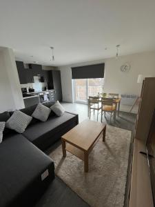 - un salon avec un canapé et une table dans l'établissement 2 Bedroom City Centre Apartment in Hemel Hempstead, à Hemel Hempstead