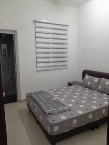 uma cama com lençóis de bolinhas num quarto em Simple Home Taiping 简居 @ Suria Aman em Kamunting