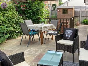 a patio with a table and chairs on a patio at Walnut Cottage in Long Melford