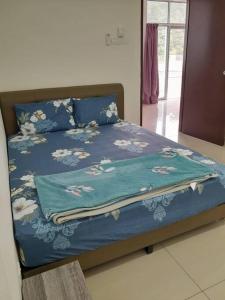 uma cama com um cobertor azul em cima em Simple Home Taiping 简居 @ Suria Aman em Kamunting