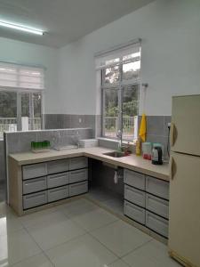 uma grande cozinha com um lavatório e um frigorífico em Simple Home Taiping 简居 @ Suria Aman em Kamunting