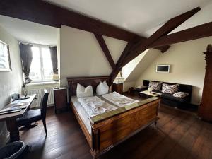 ein Schlafzimmer mit einem großen Bett und einem Schreibtisch in der Unterkunft Hotel Schloss Grochwitz (garni) in Herzberg