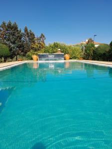 uma grande piscina de gua azul com uma fonte em Villa Silene na Covilh