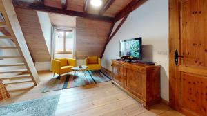 uma sala de estar com televisão num armário de madeira em Les Appartements Manala - Turckheim em Turckheim