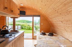 a kitchen with an archway in a tiny house at 68 Degrees West Glamping in Brecon