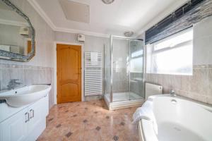 a bathroom with a tub and a sink and a shower at *105* Setup for your most relaxed & amazing stay + Free Parking + Free Fast WiFi * in Batley