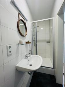 a white bathroom with a sink and a shower at Hotel My My in Lahnstein