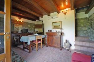 ein Esszimmer mit einem Tisch und einer Küche in der Unterkunft Villa Le Due Lune with Pool by VILLASRETREATS in Filattiera