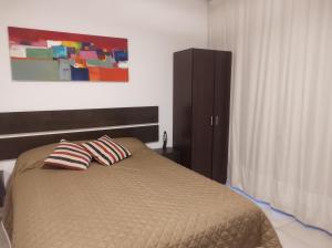 a bedroom with a bed with two pillows on it at Temporarios Sanatorios CENTRO in Rosario