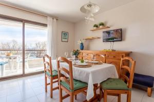 une salle à manger avec une table, des chaises et une télévision dans l'établissement Bonaire, à L'Escala
